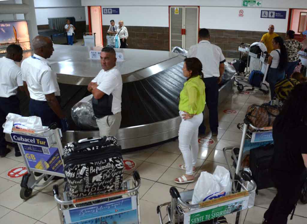 Pasajeros recibiendo equipajes